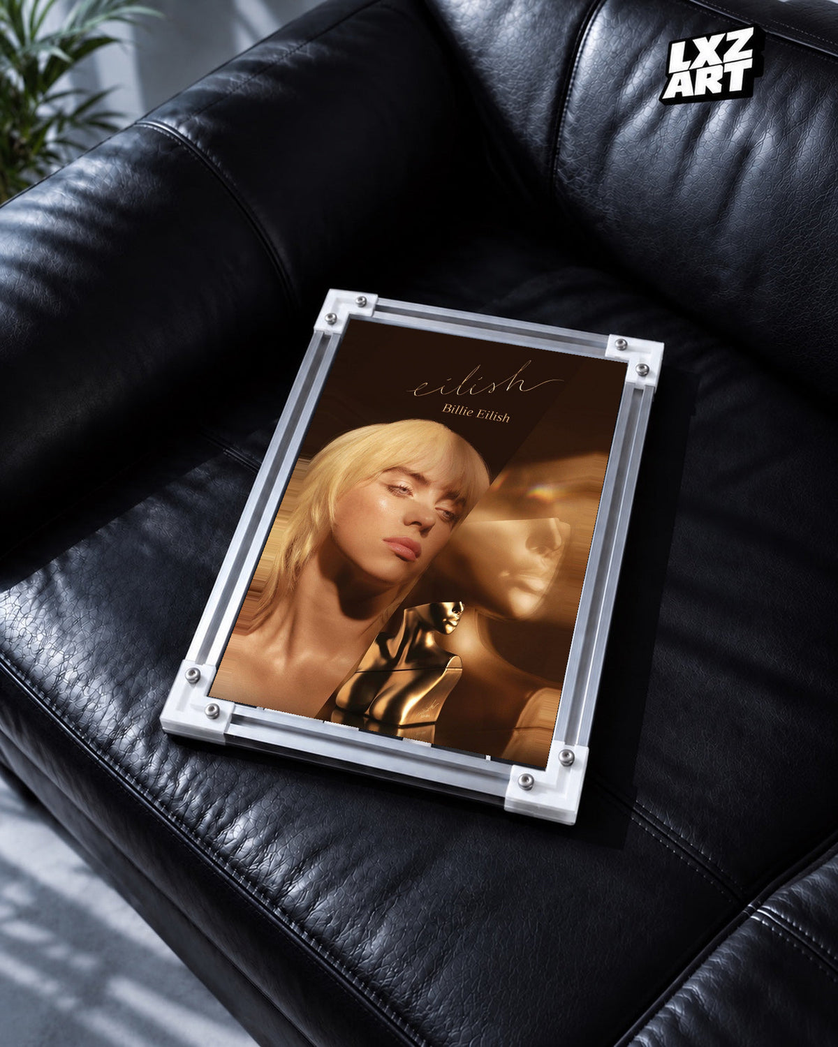 Billie Eilish Golden Portrait Poster in white-corner frame on black leather sofa. Frame shown for display only.