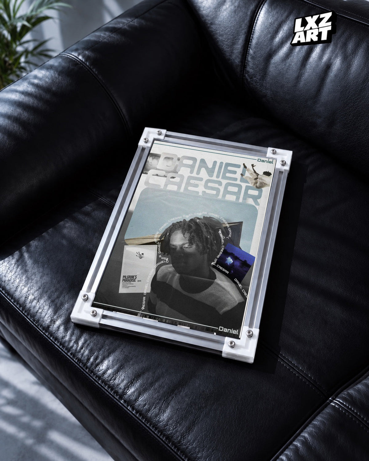 Daniel Caesar Blue Album Collage Poster in white-corner frame on black leather sofa. Frame shown for display only.