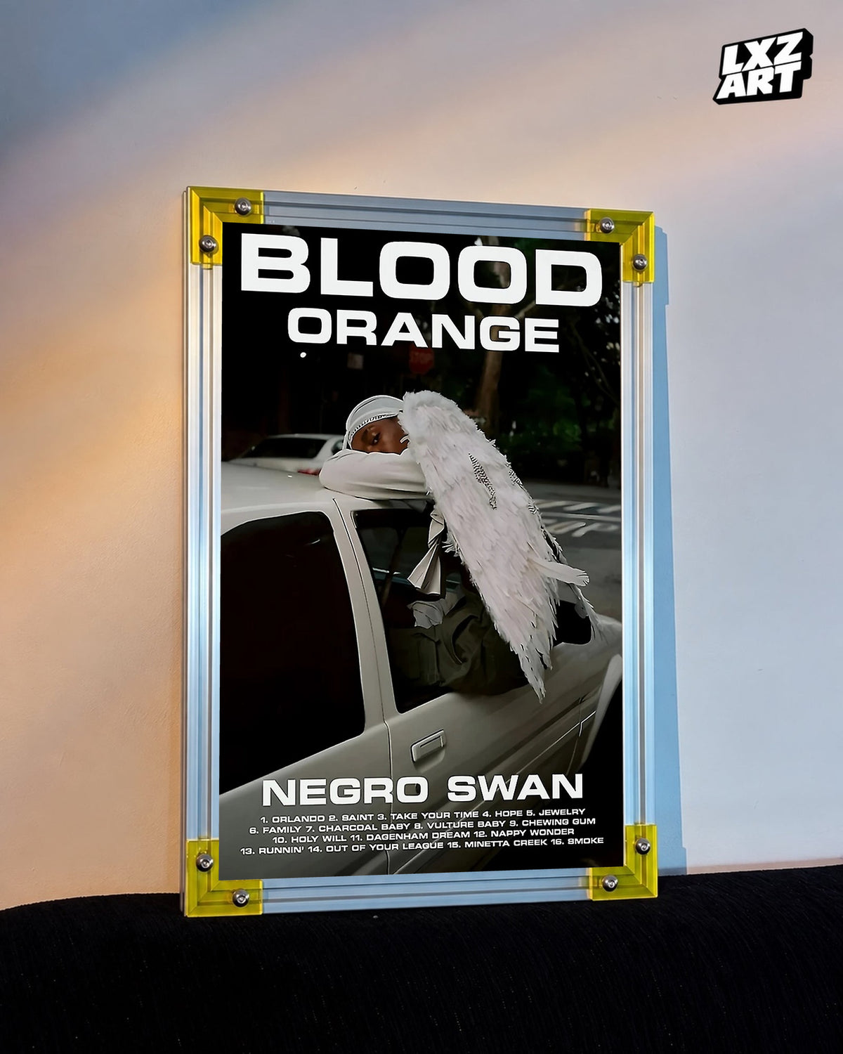 Blood Orange Negro Swan bold white type poster displayed against a warm-lit wall in the yellow-corner frame; unframed print, frame not included