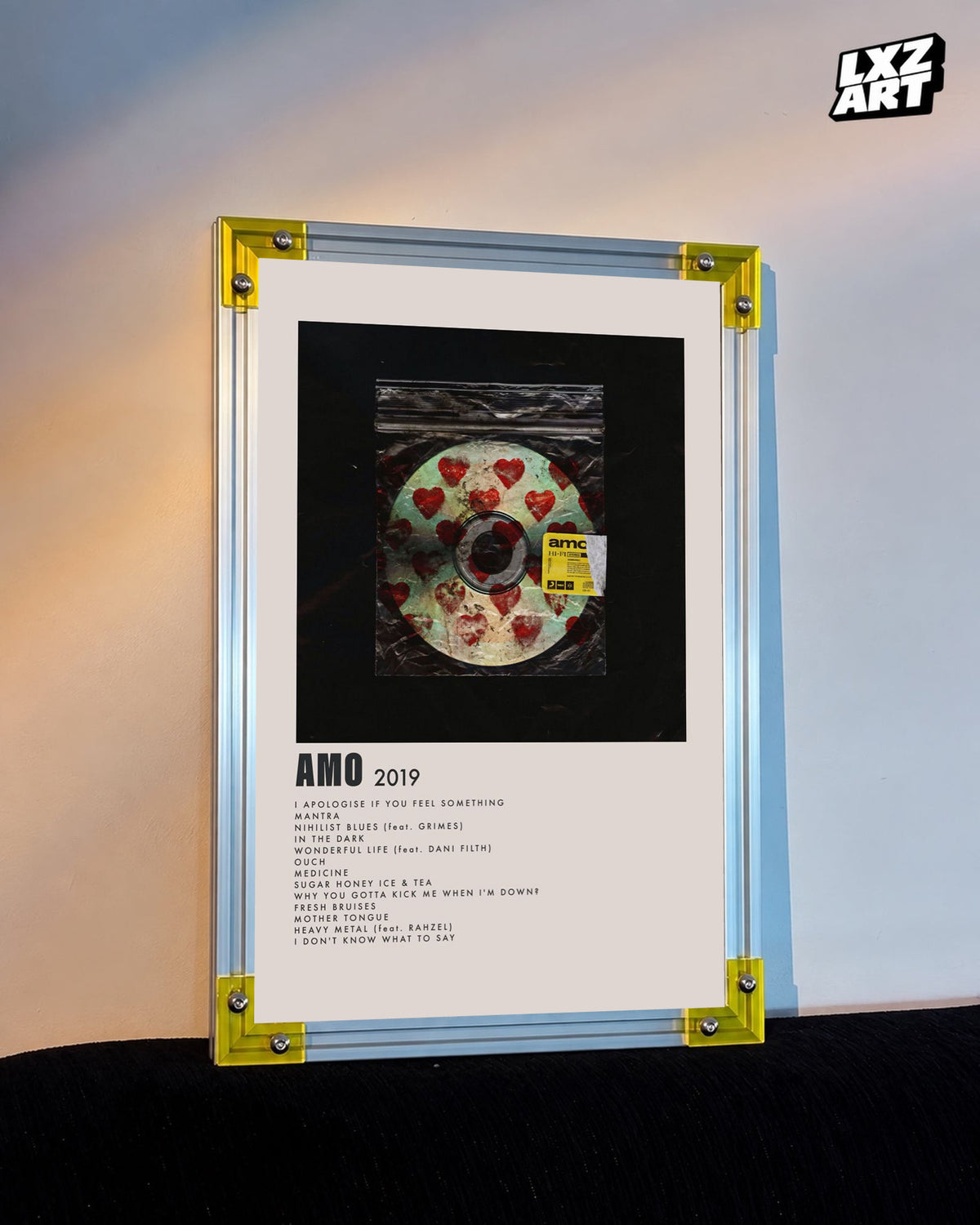 Bring Me The Horizon amo heart disc tracklist poster displayed against a warm wall in a yellow-corner frame; unframed print, frame not included