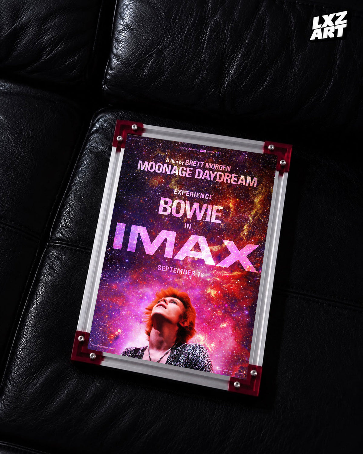 David Bowie Moonage Daydream IMAX Galaxy poster displayed on black leather sofa with red frame corners; frame not included
