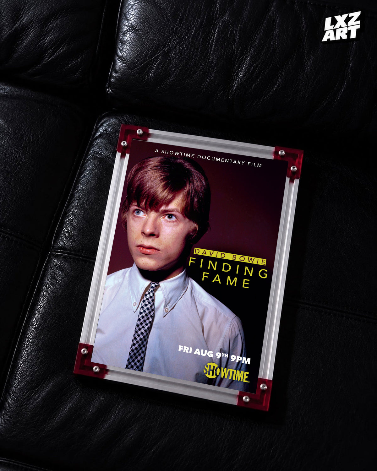 David Bowie Finding Fame Portrait poster displayed on black leather sofa with red frame corners; frame not included