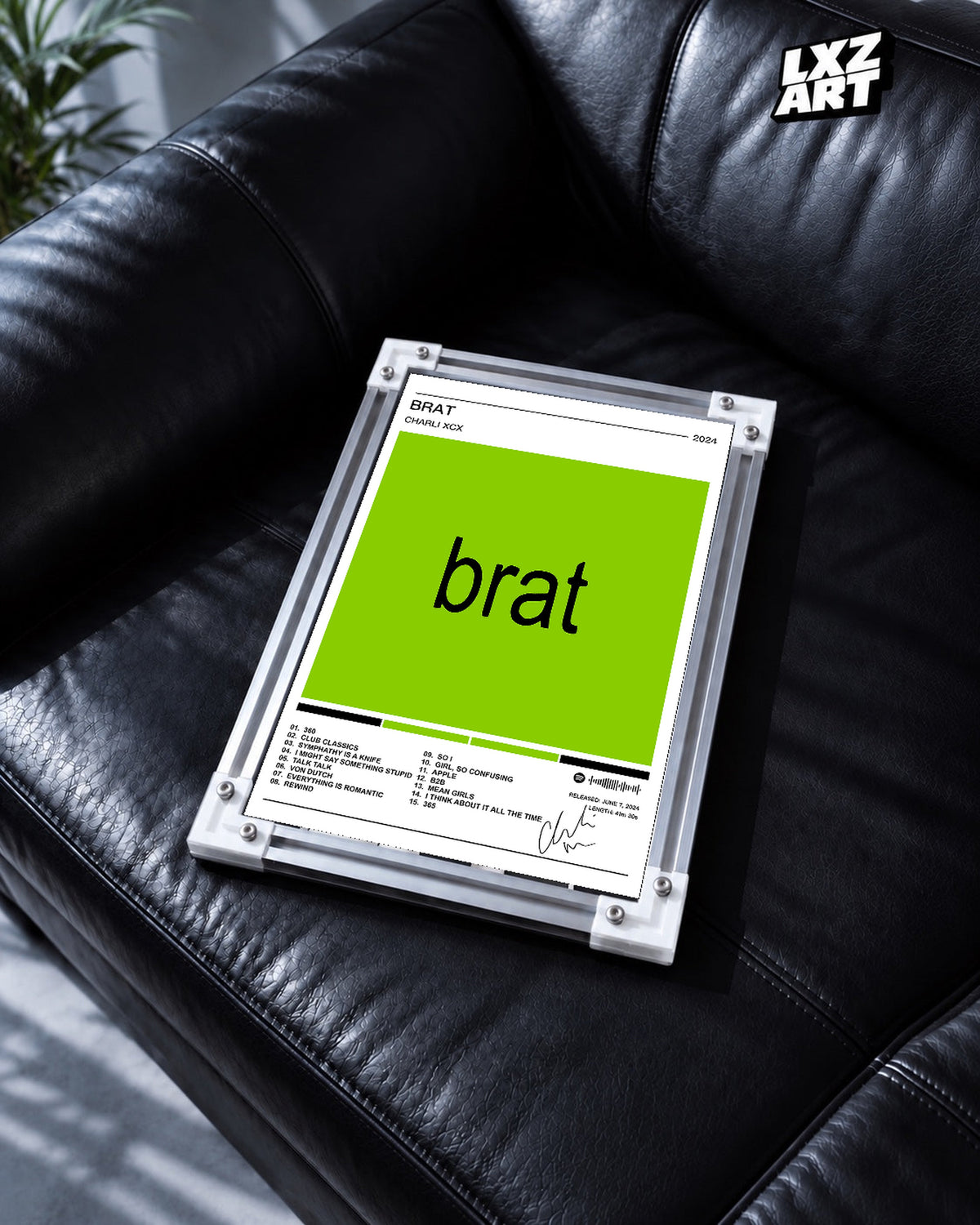 Charli xcx Brat White Tracklist unframed poster shown in the black leather sofa display.