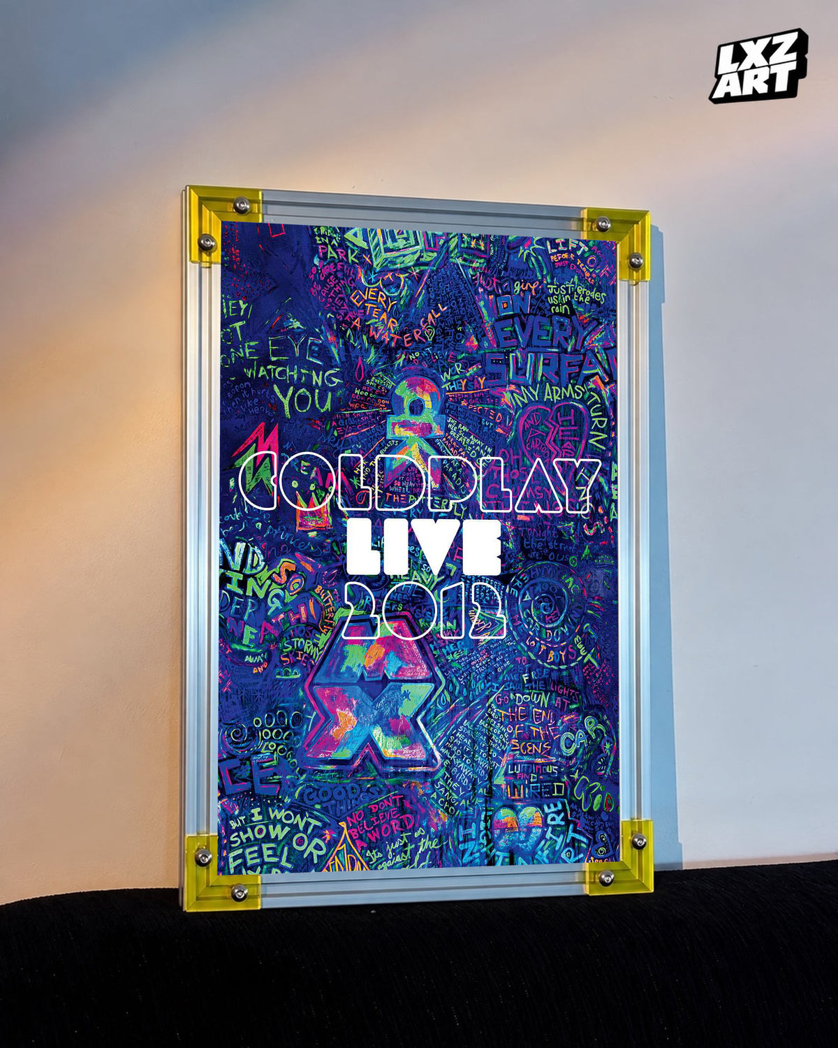Coldplay Live 2012 Graffiti Concert Film Poster displayed against a warm wall in a yellow-corner frame; unframed print, frame not included