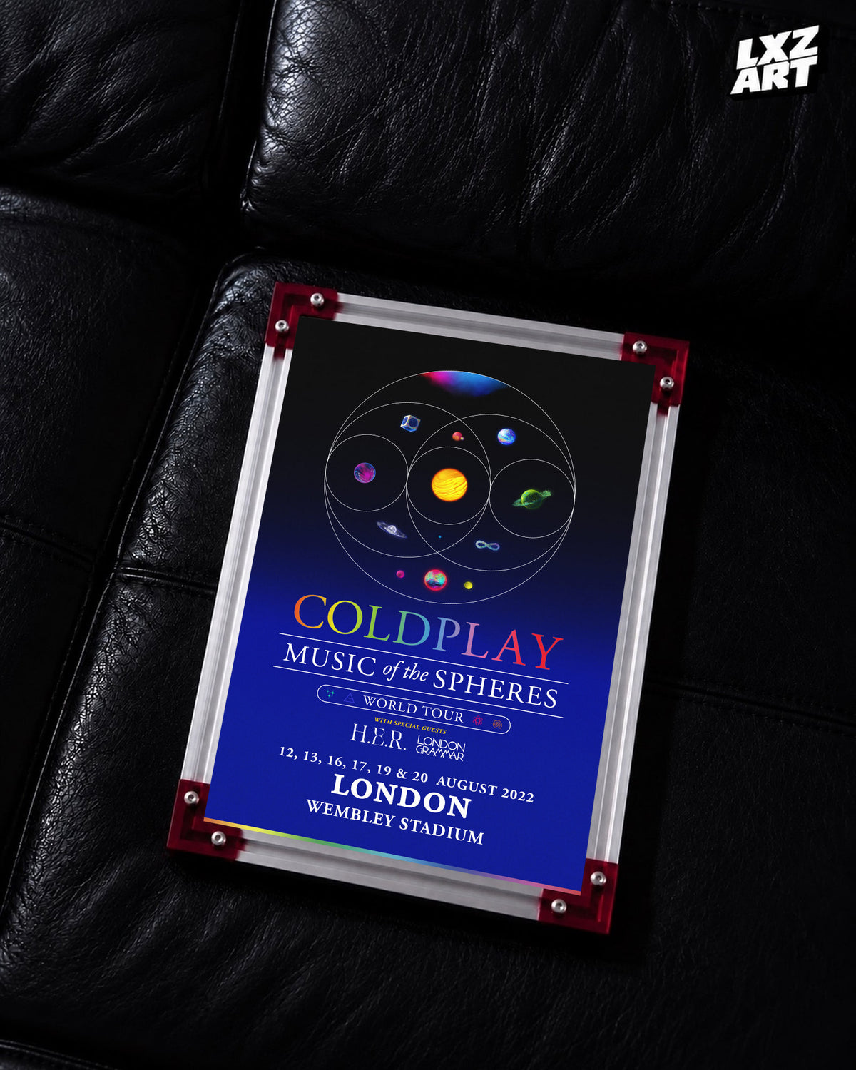 Coldplay Music of the Spheres London 2022 Tour Poster displayed on a black leather sofa in a red-corner frame; unframed print, frame not included