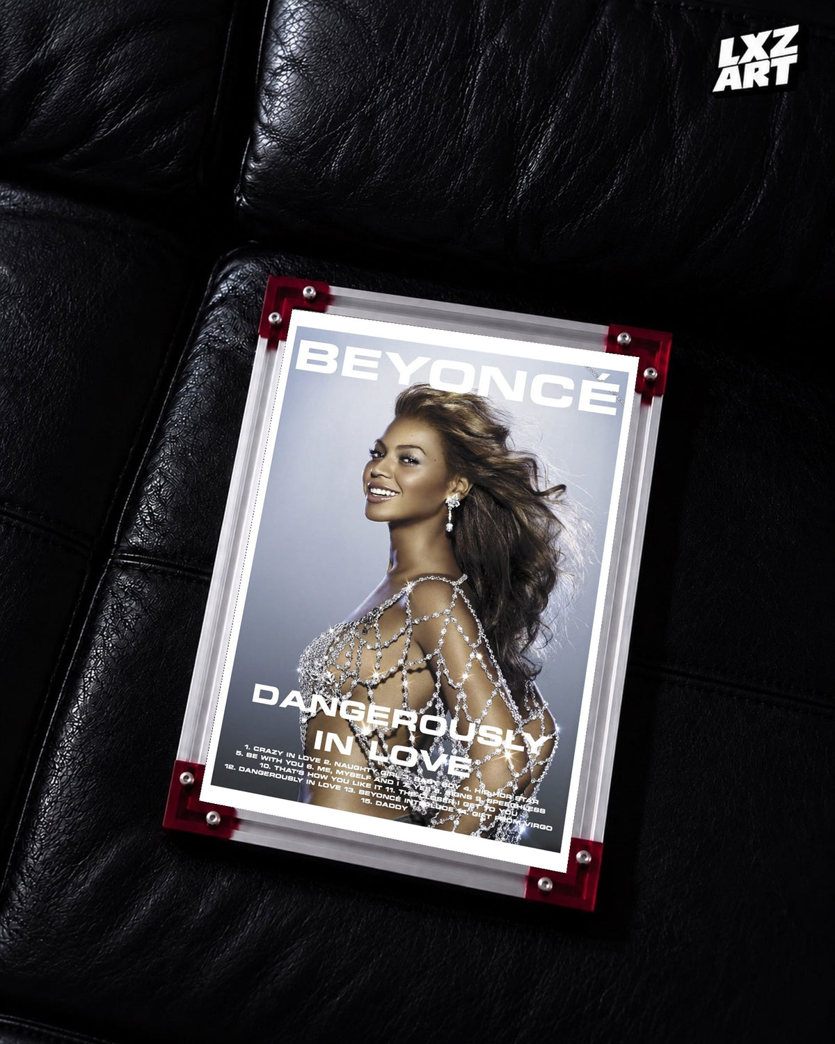 Beyoncé Dangerously in Love tracklist poster displayed on a black leather sofa in a red corner frame; unframed print, frame not included