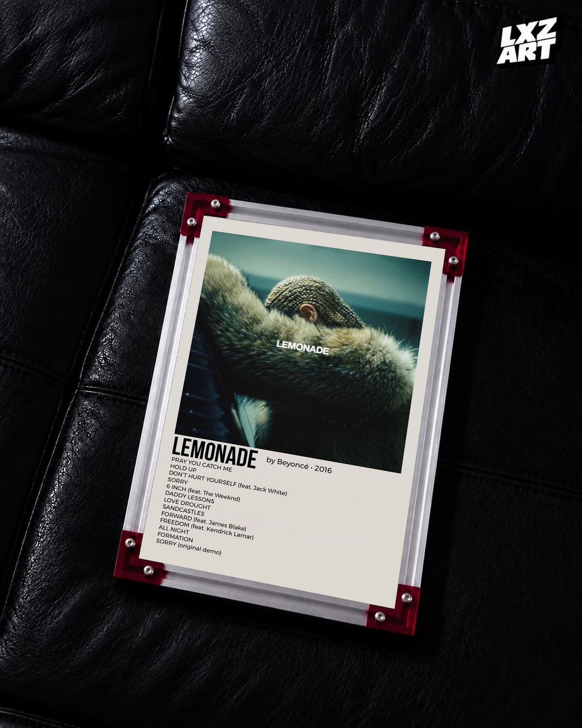 Beyoncé Lemonade tracklist poster displayed on a black leather sofa in a red corner frame; unframed print, frame not included