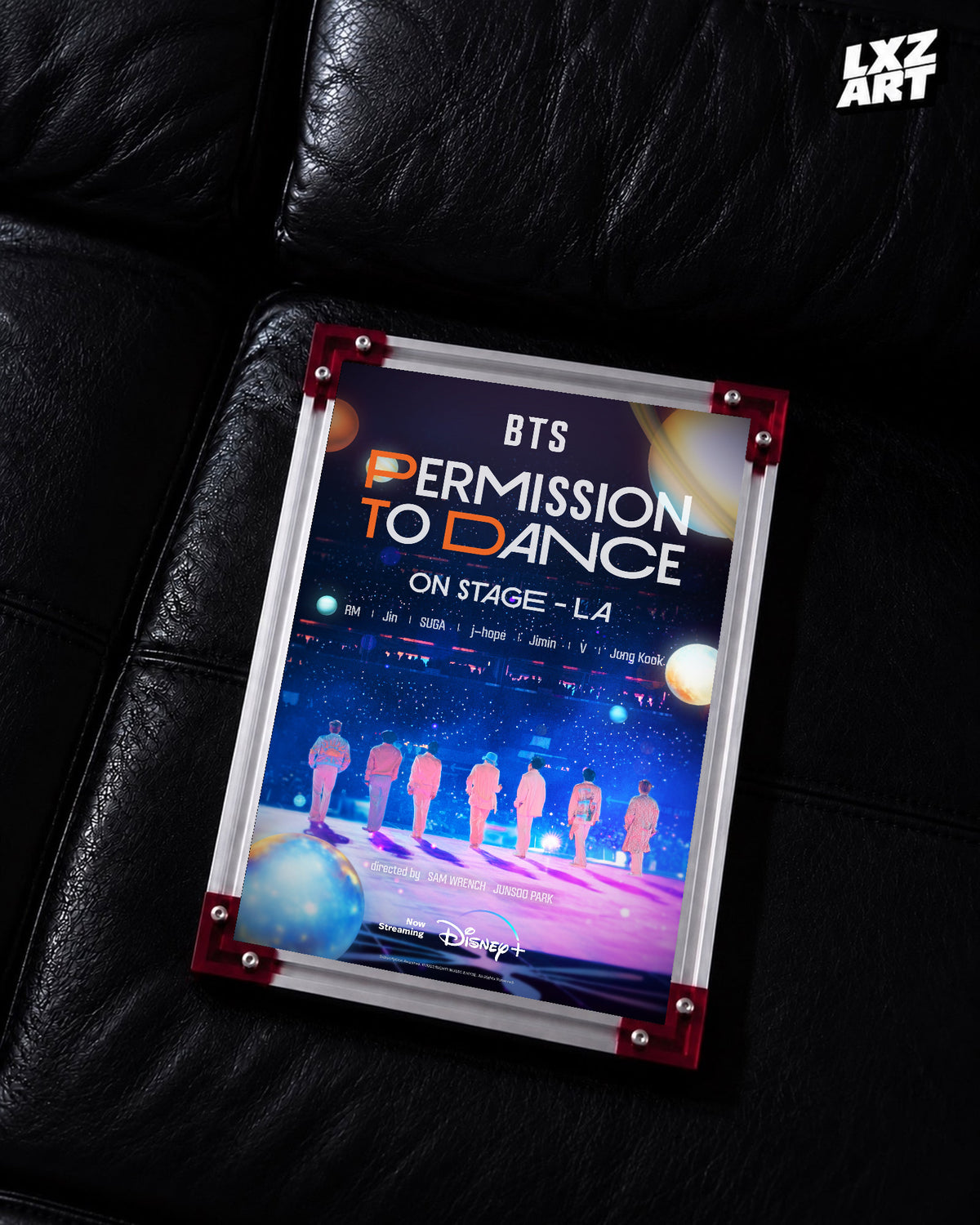 BTS Permission to Dance on Stage LA concert film poster displayed on a black leather sofa in a red-corner frame; unframed print, frame not included