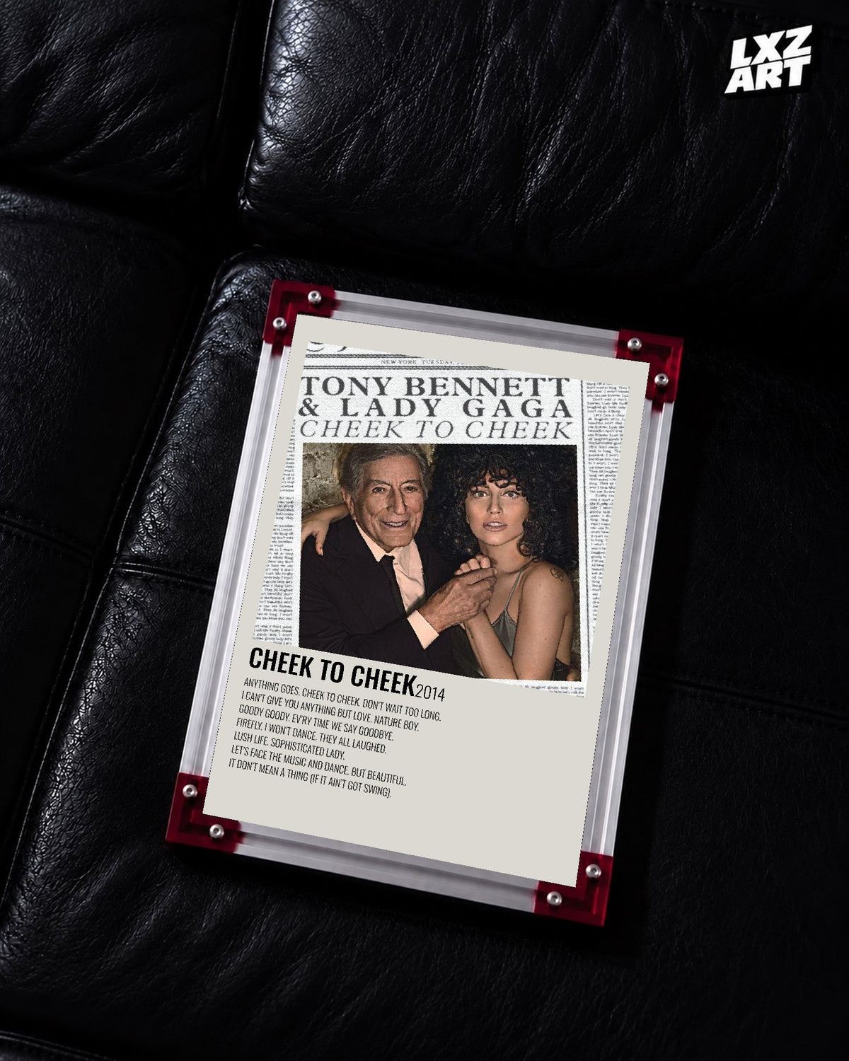 Lady Gaga & Tony Bennett Cheek to Cheek tracklist poster displayed on a black leather sofa in a red corner frame; unframed print, frame not included
