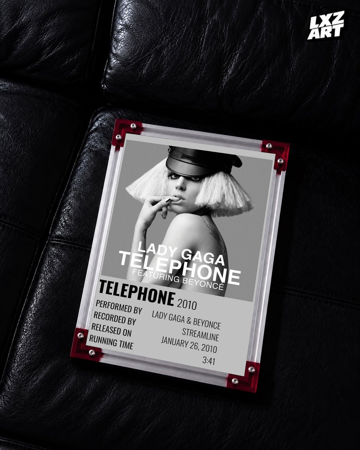 Lady Gaga feat. Beyoncé Telephone single cover poster displayed on a black leather sofa in a red corner frame; unframed print, frame not included