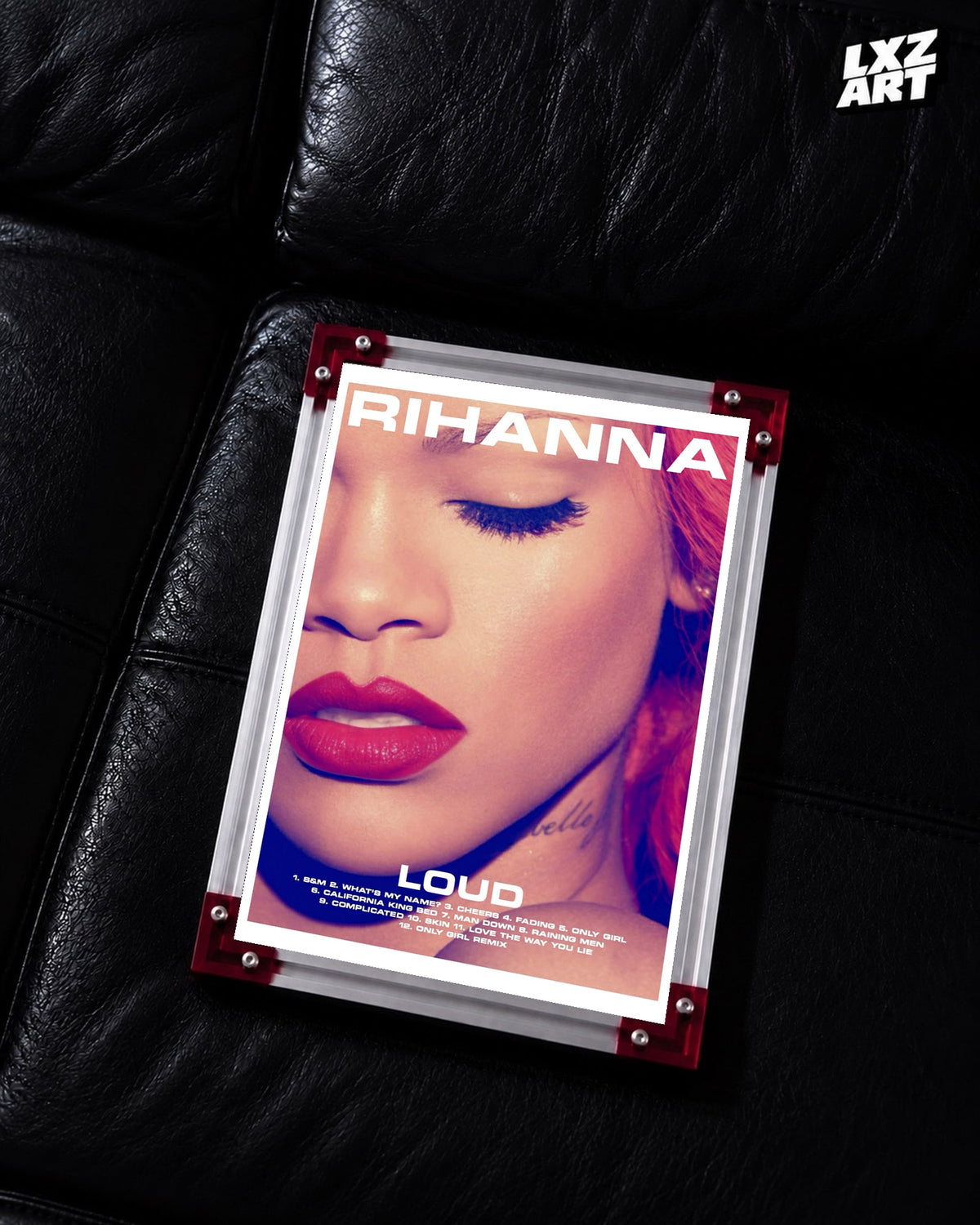 Rihanna Loud album tracklist poster displayed on a black leather sofa in a red corner frame; unframed print, frame not included