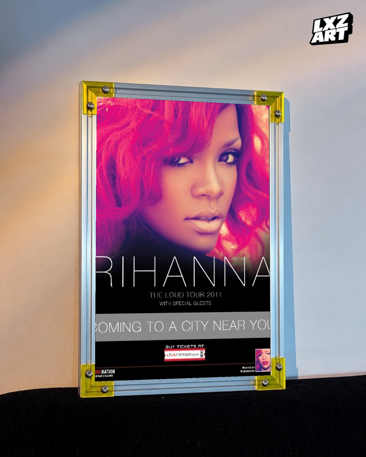 Rihanna Loud Tour 2011 concert poster displayed against a warm wall in a yellow corner frame; unframed print, frame not included