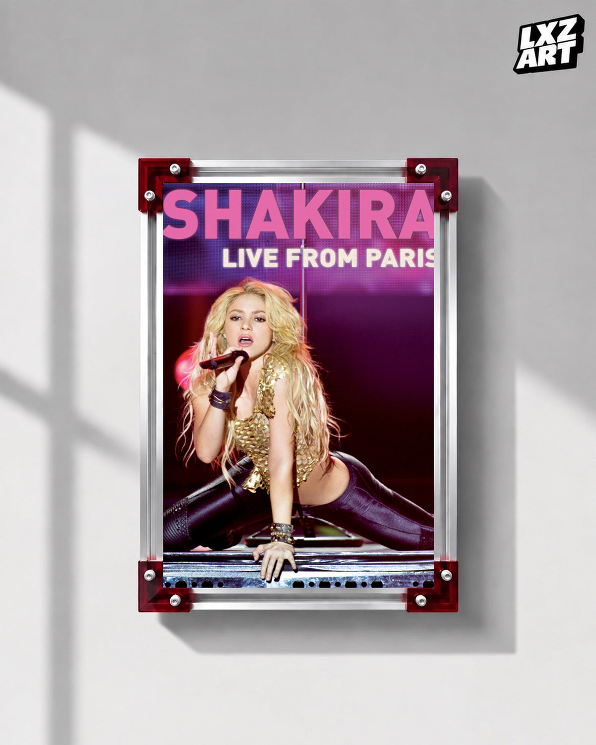 Shakira Live from Paris concert film poster displayed on a gray wall in a red corner frame; unframed print, frame not included