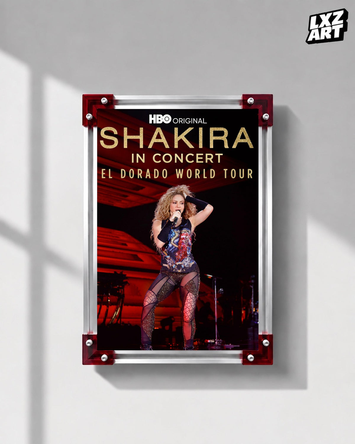 Shakira In Concert: El Dorado World Tour concert film poster displayed on a gray wall in a red corner frame; unframed print, frame not included