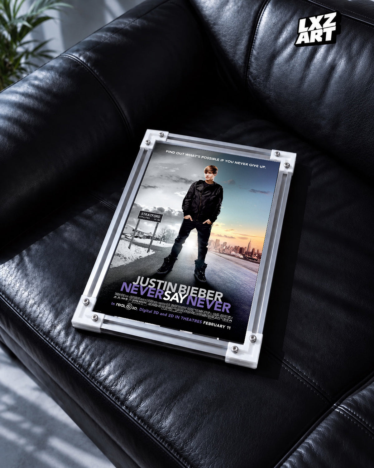 Justin Bieber Never Say Never City Road Concert Film Poster displayed in a white-corner frame on a black leather sofa. Frame for display only.