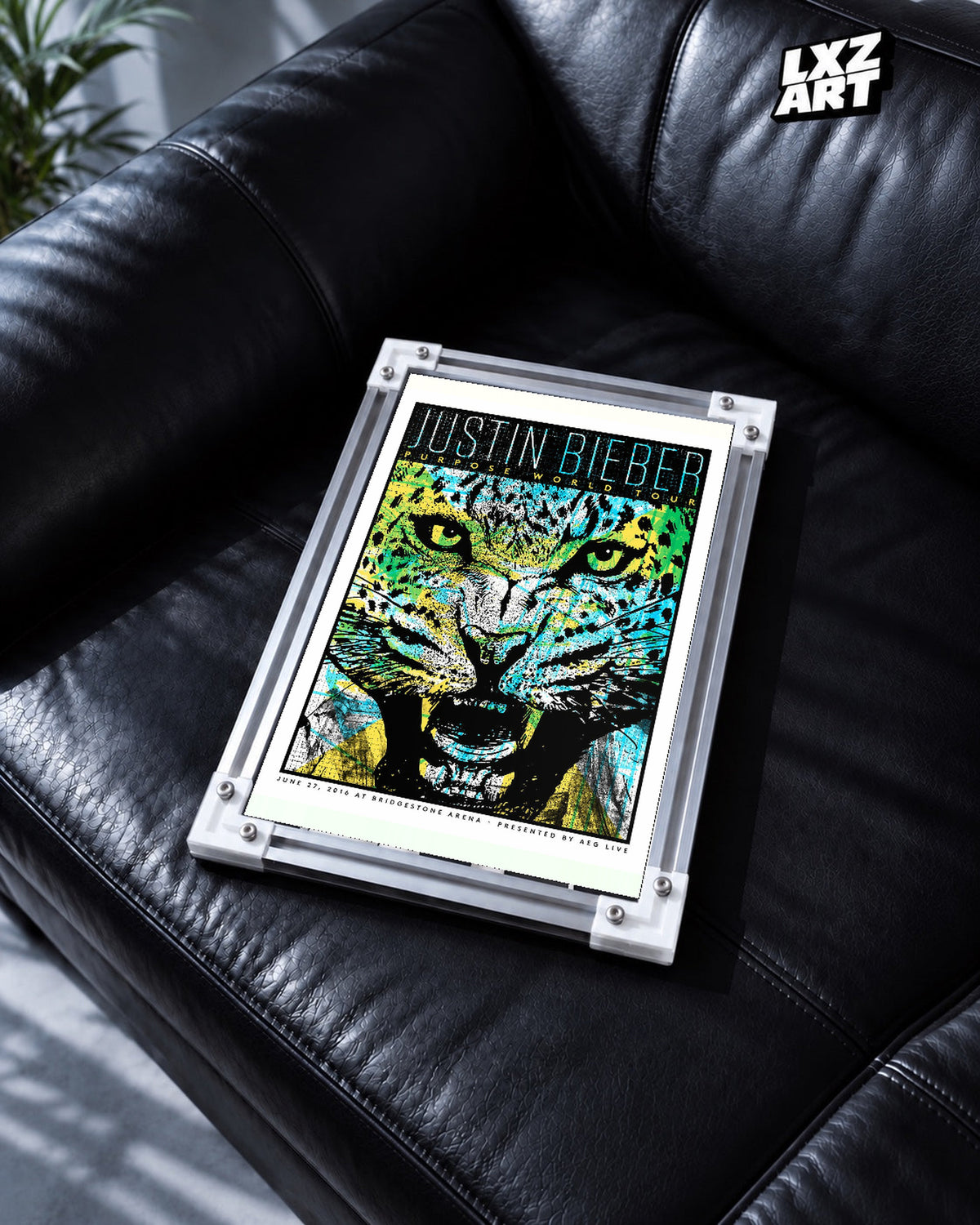 Justin Bieber Purpose World Tour Nashville Jaguar Poster displayed in a white-corner frame on a black leather sofa. Frame for display only.