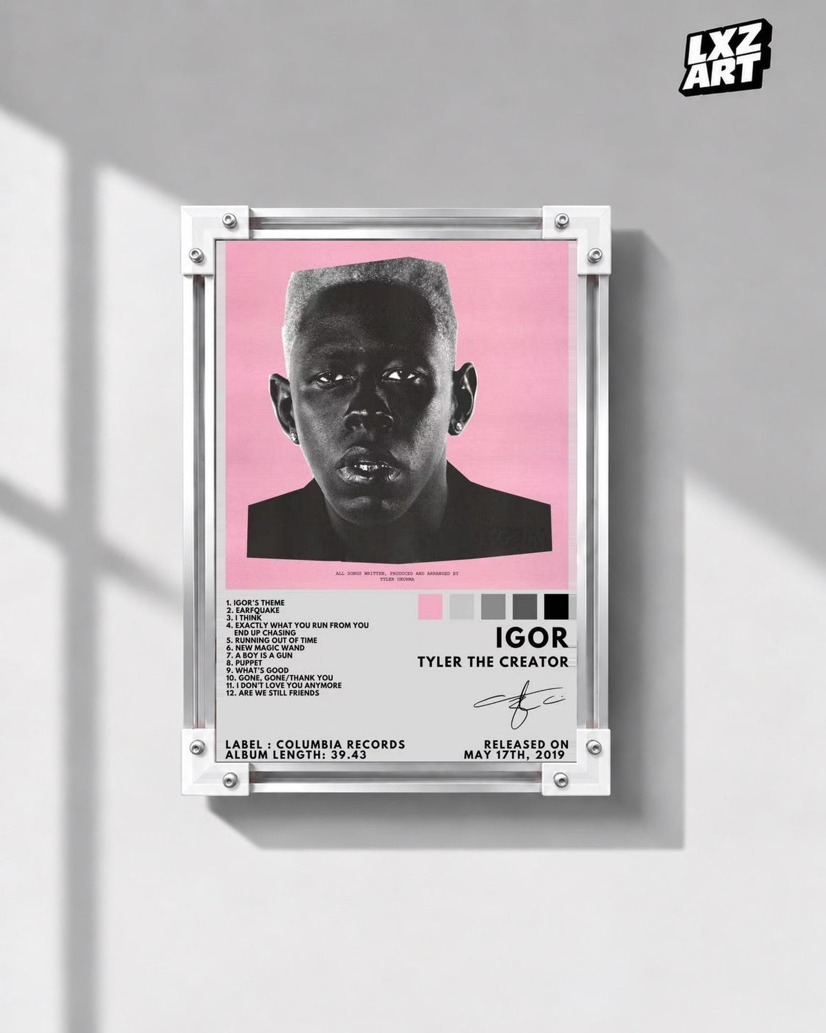 Tyler, The Creator IGOR Tracklist Poster in white-corner frame on gray wall. Frame shown for display only.