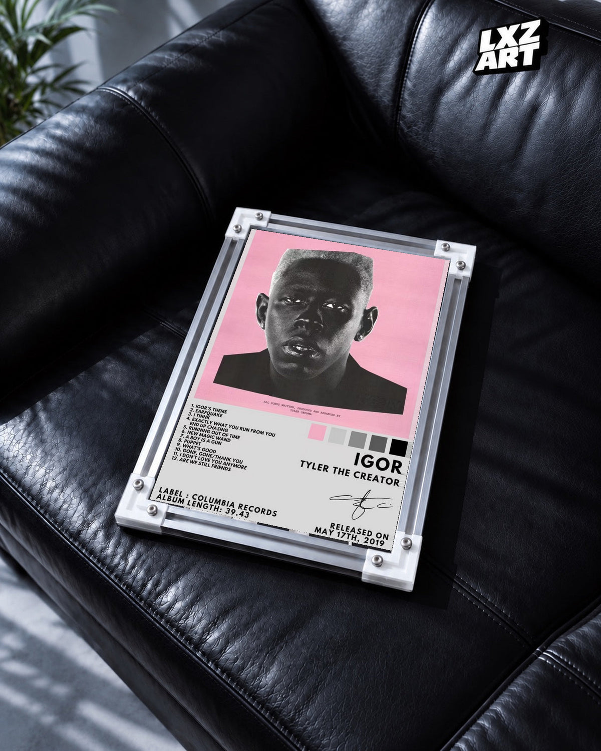 Tyler, The Creator IGOR Tracklist Poster in white-corner frame on black leather sofa. Frame shown for display only.