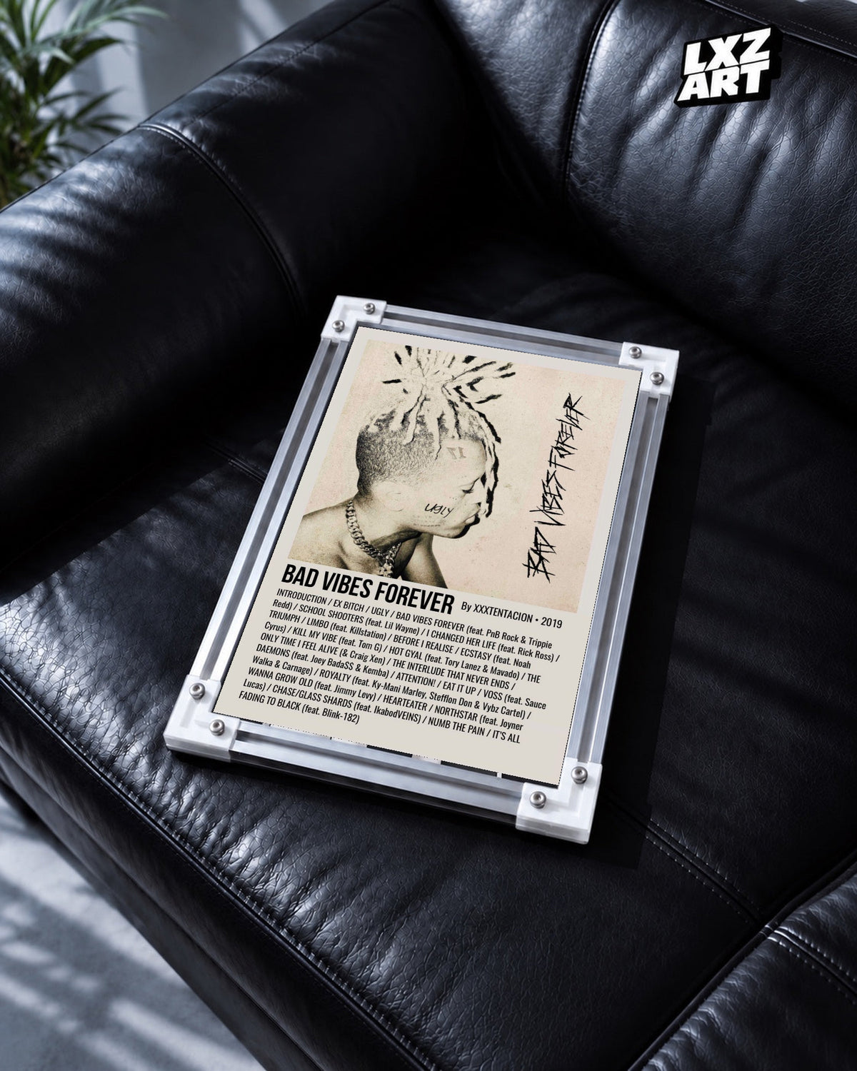 XXXTentacion Bad Vibes Forever Album Tracklist Poster in white-corner frame on black leather sofa. Frame shown for display only.