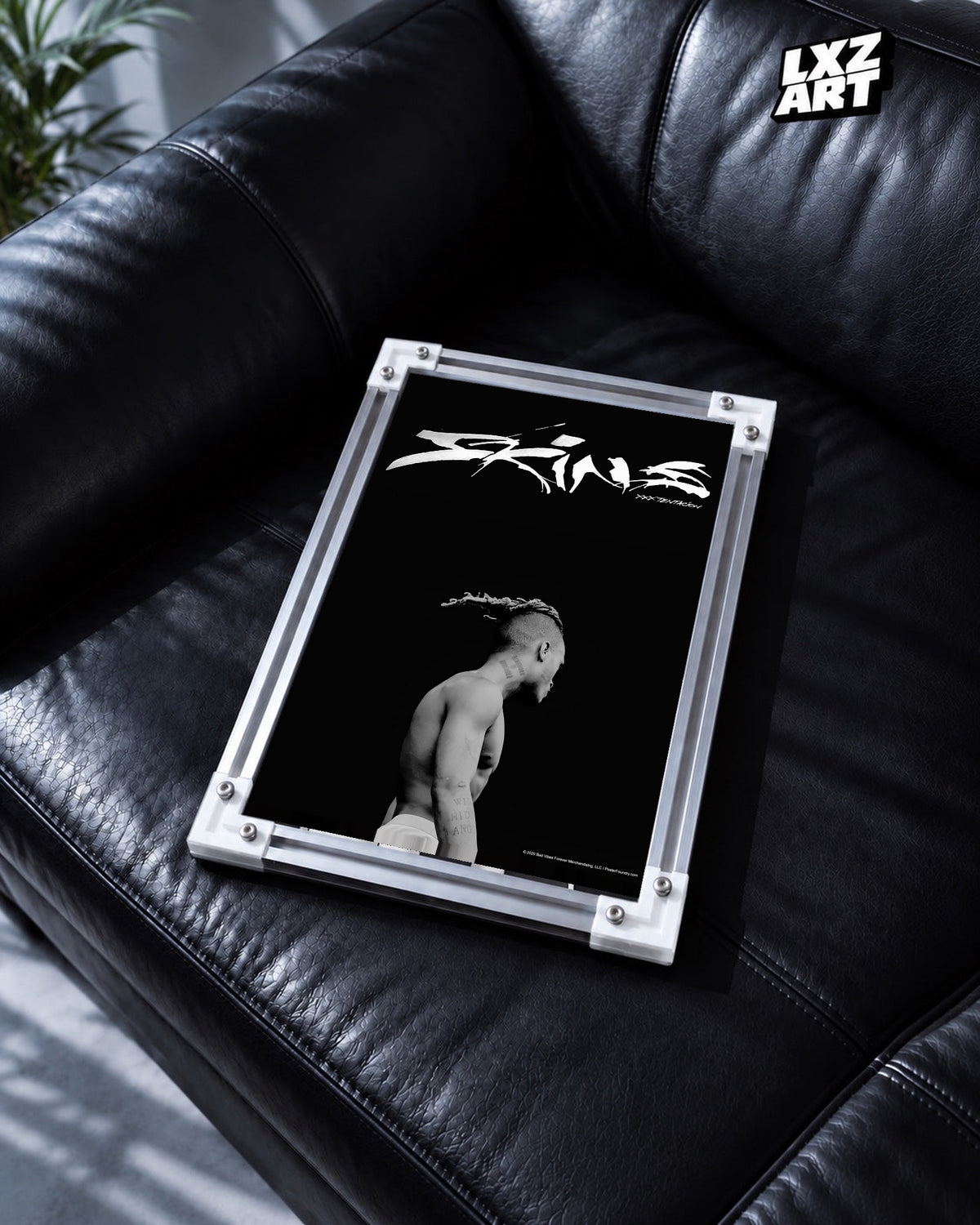 XXXTentacion Skins Minimal Black Poster in white-corner frame on black leather sofa. Frame shown for display only.