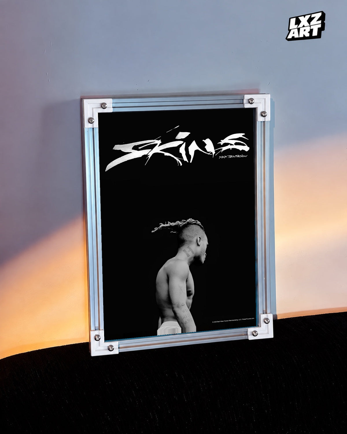 XXXTentacion Skins Minimal Black Poster in white-corner frame beside warm-lit wall. Frame shown for display only.