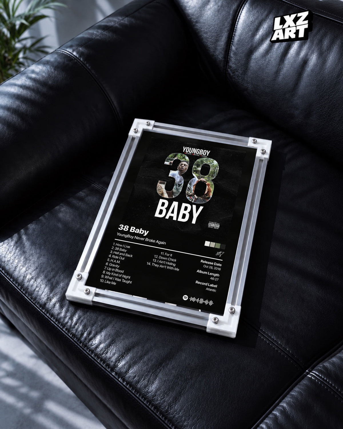 YoungBoy Never Broke Again 38 Baby Tracklist Poster in white-corner frame on black leather sofa. Frame shown for display only.