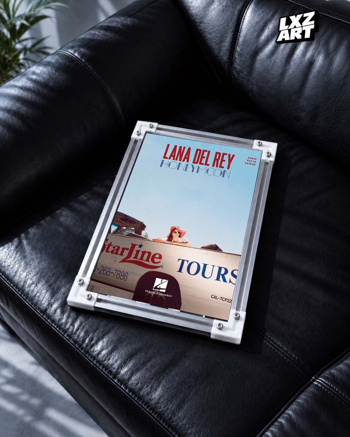 Lana Del Rey Honeymoon Blue Sky Songbook Cover Poster in white-corner frame on black leather sofa. Frame shown for display only.