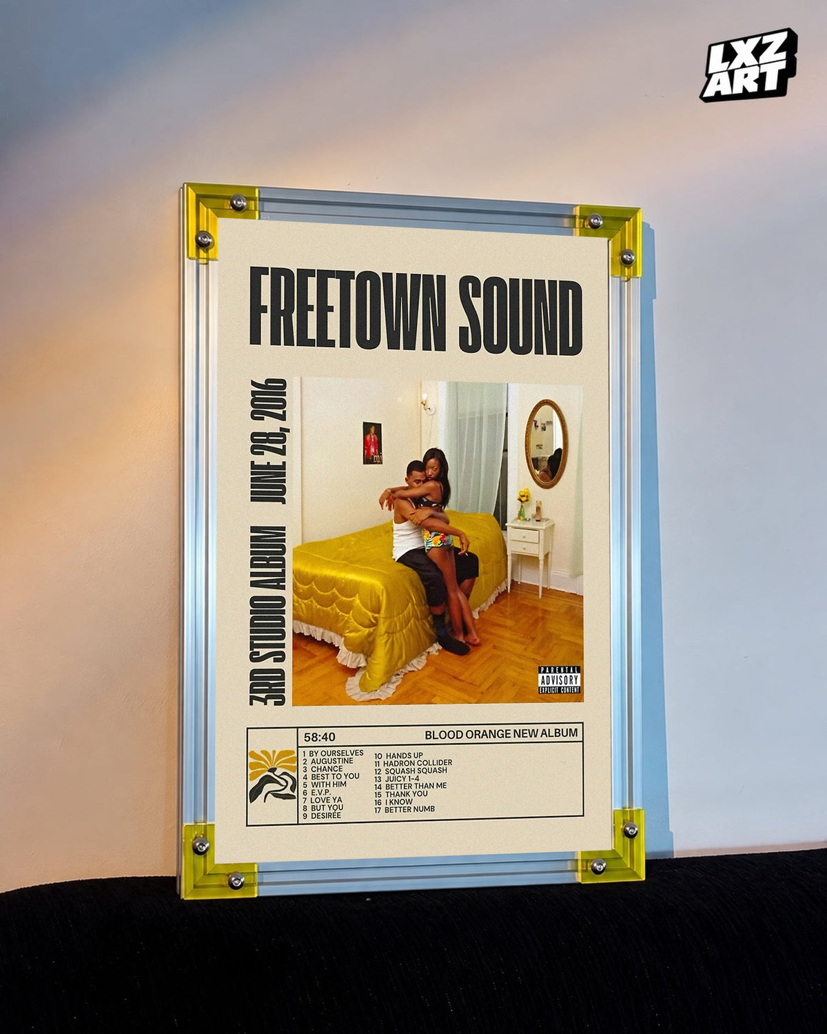 Blood Orange Freetown Sound bold title tracklist poster displayed against a warm-lit wall in the yellow-corner frame; unframed print, frame not included