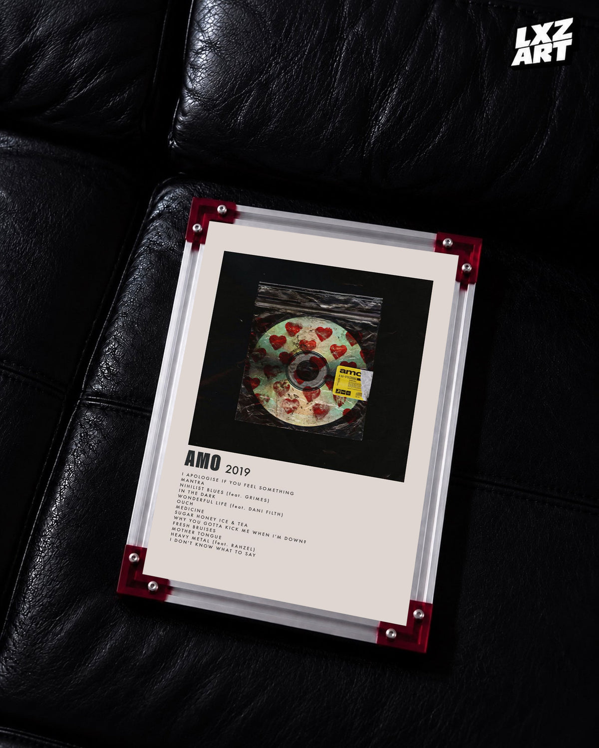 Bring Me The Horizon amo heart disc tracklist poster displayed on a black leather sofa in a red-corner frame; unframed print, frame not included