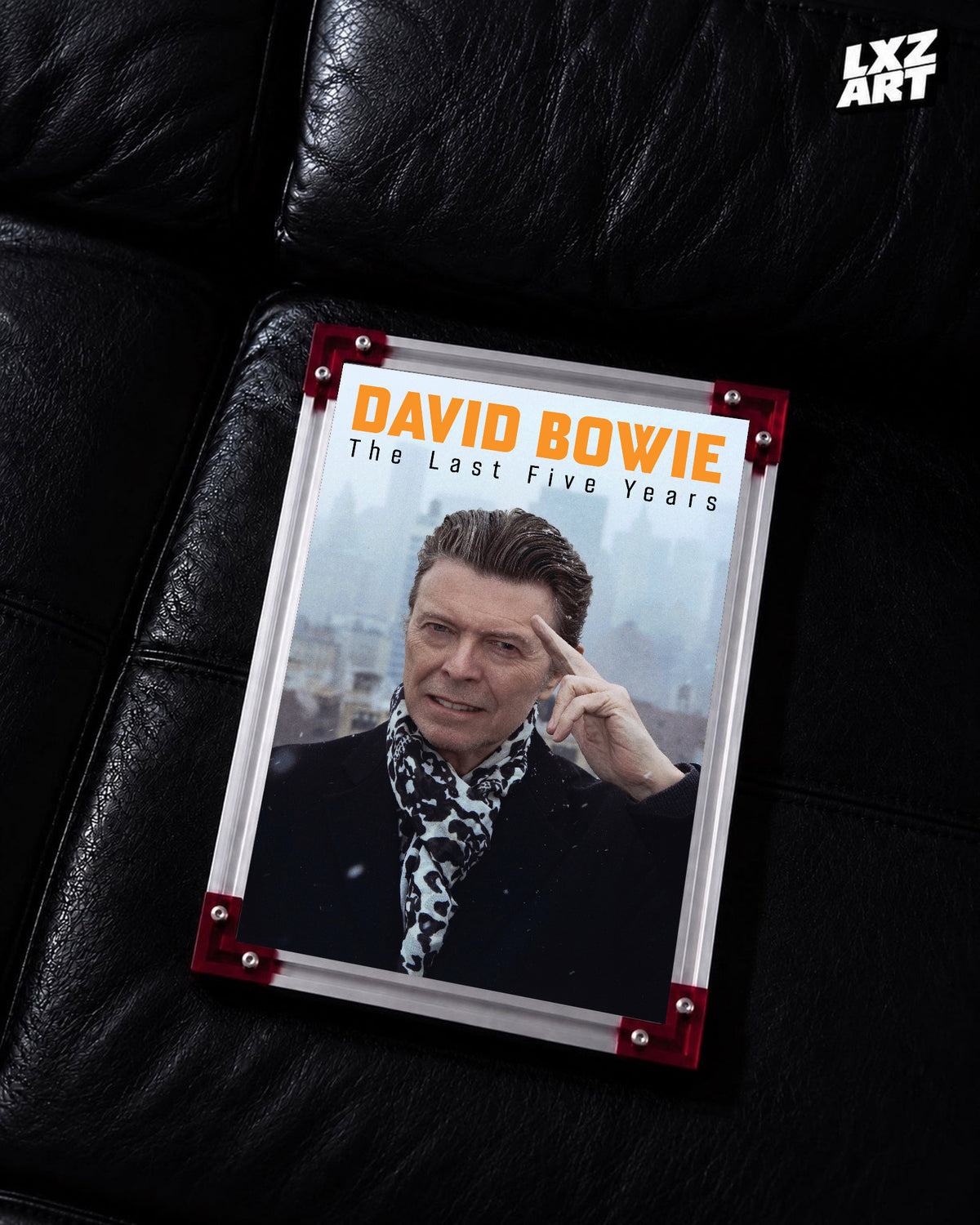 David Bowie The Last Five Years Portrait poster displayed on black leather sofa with red frame corners; frame not included
