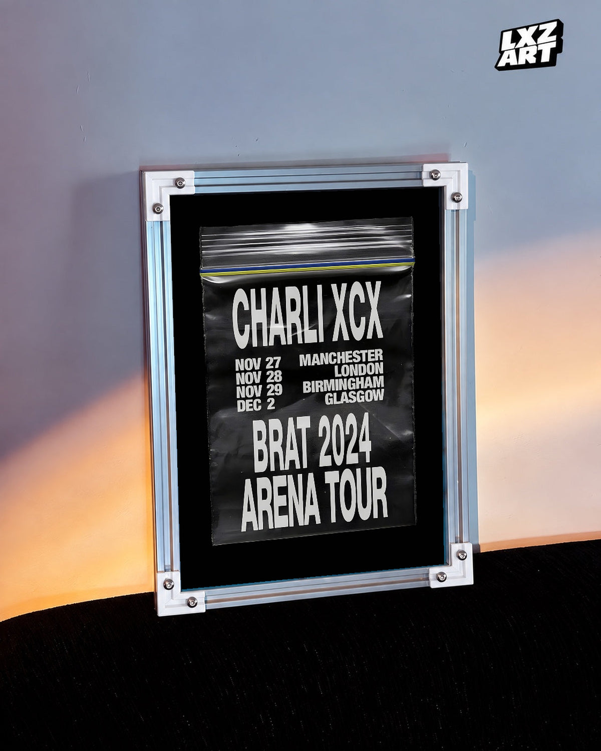 Charli xcx Brat 2024 UK Arena Tour Zip Bag unframed poster shown in the warm-lit wall display.