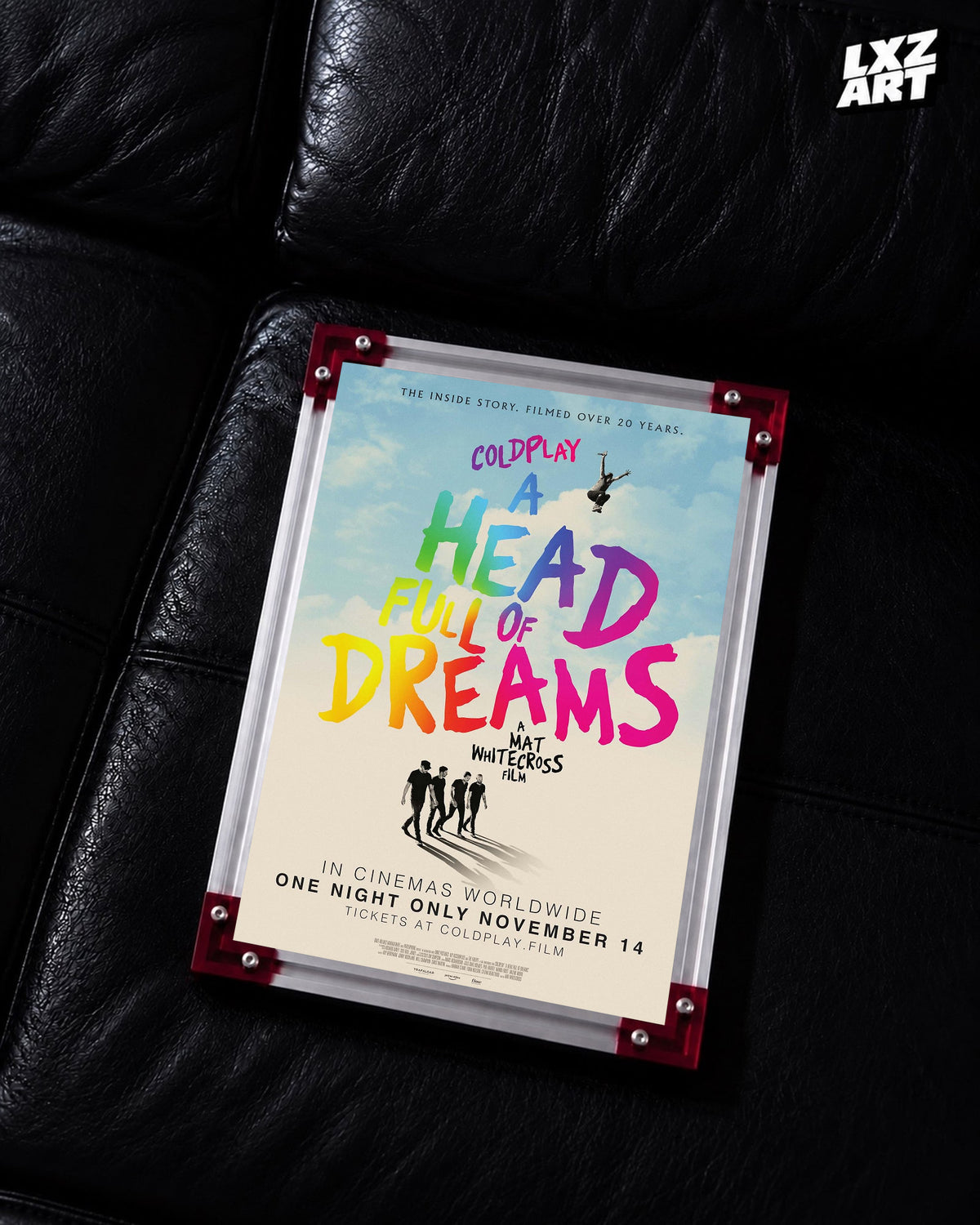 Coldplay A Head Full of Dreams Documentary Poster displayed on a black leather sofa in a red-corner frame; unframed print, frame not included