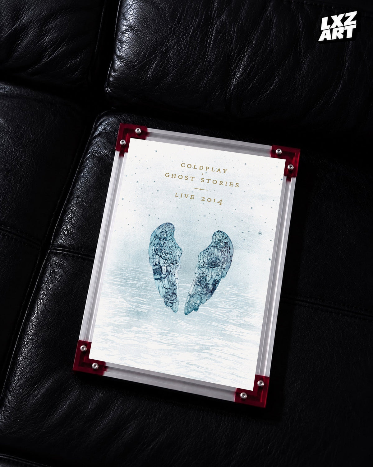 Coldplay Ghost Stories Live 2014 Poster displayed on a black leather sofa in a red-corner frame; unframed print, frame not included
