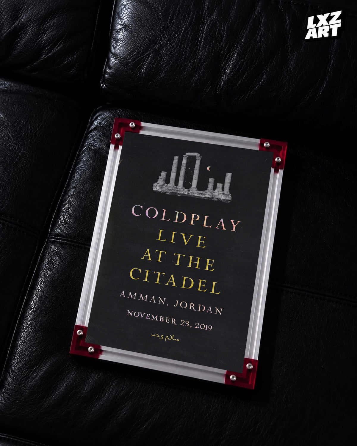 Coldplay Everyday Life Live at the Citadel Poster displayed on a black leather sofa in a red-corner frame; unframed print, frame not included