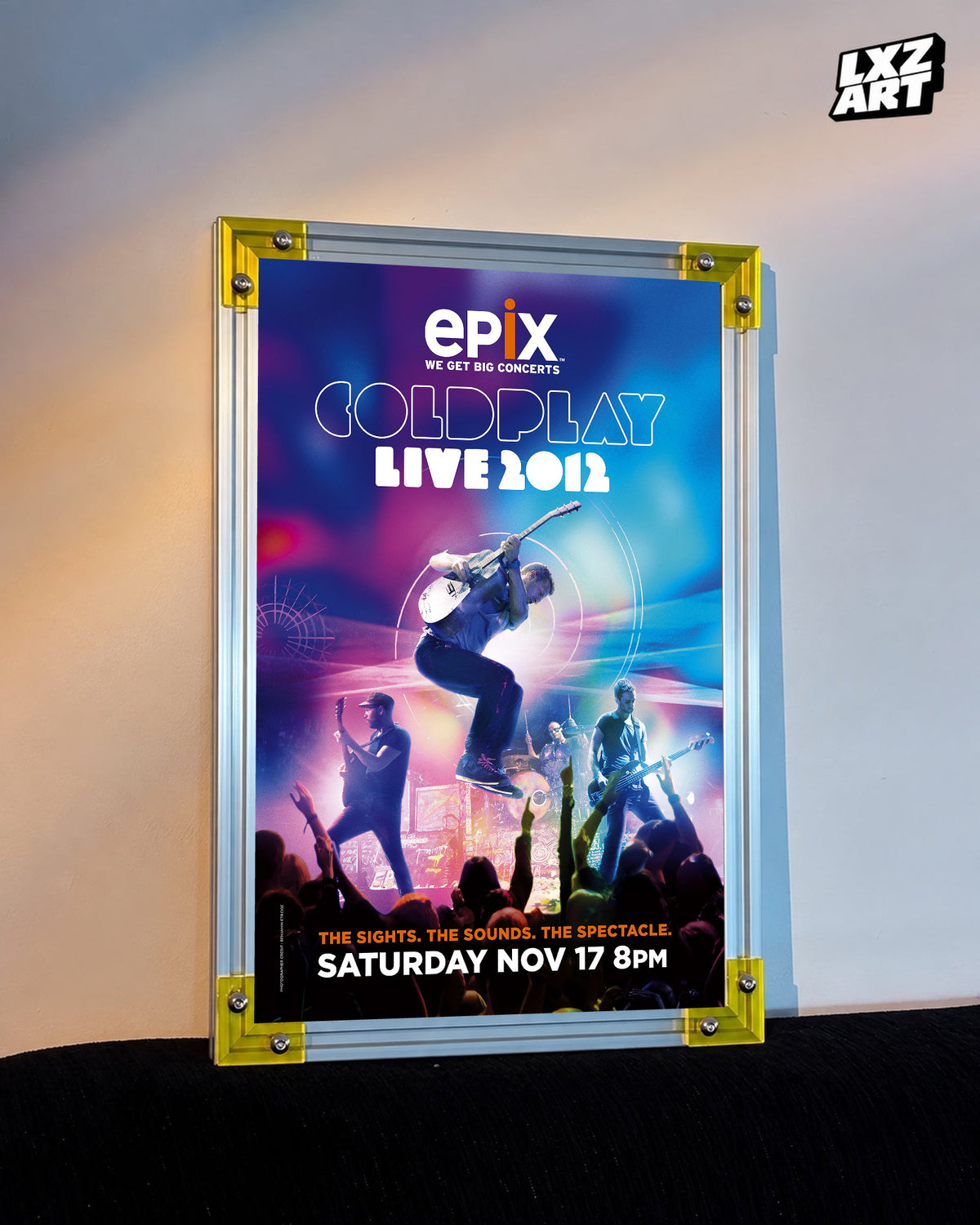 Coldplay Live 2012 Epix TV Special Poster displayed against a warm wall in a yellow-corner frame; unframed print, frame not included