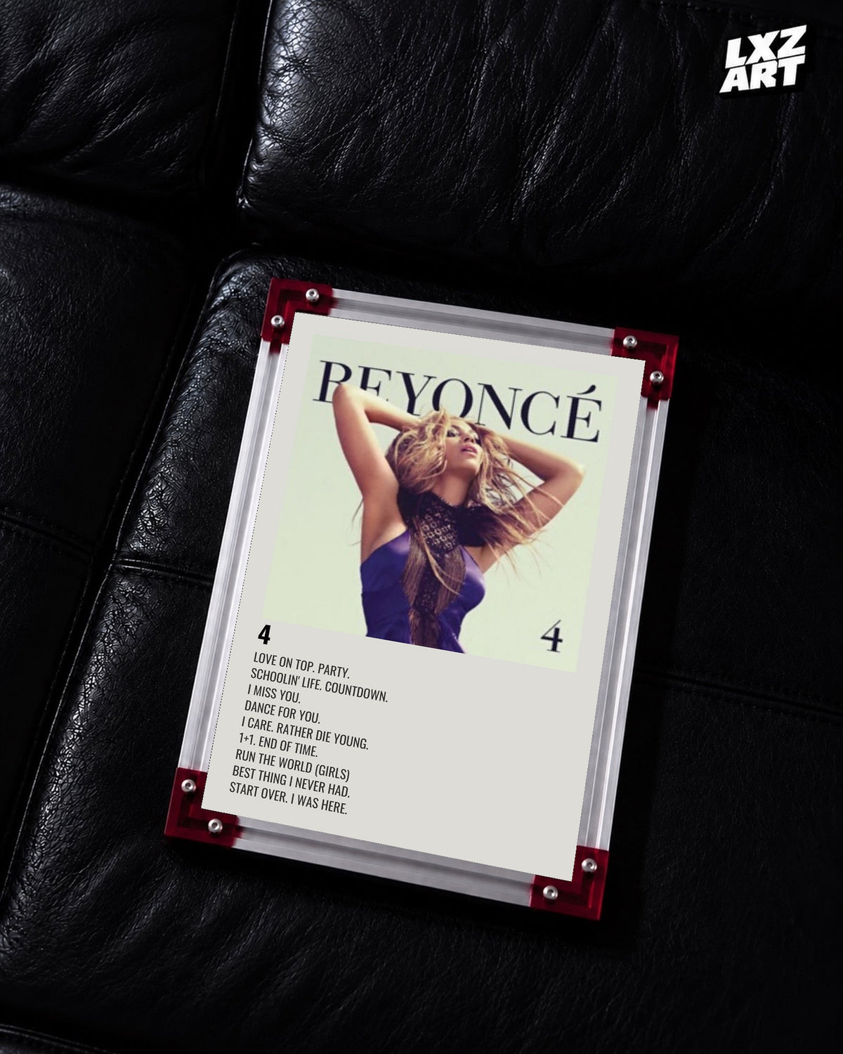 Beyoncé 4 tracklist poster displayed on a black leather sofa in a red corner frame; unframed print, frame not included