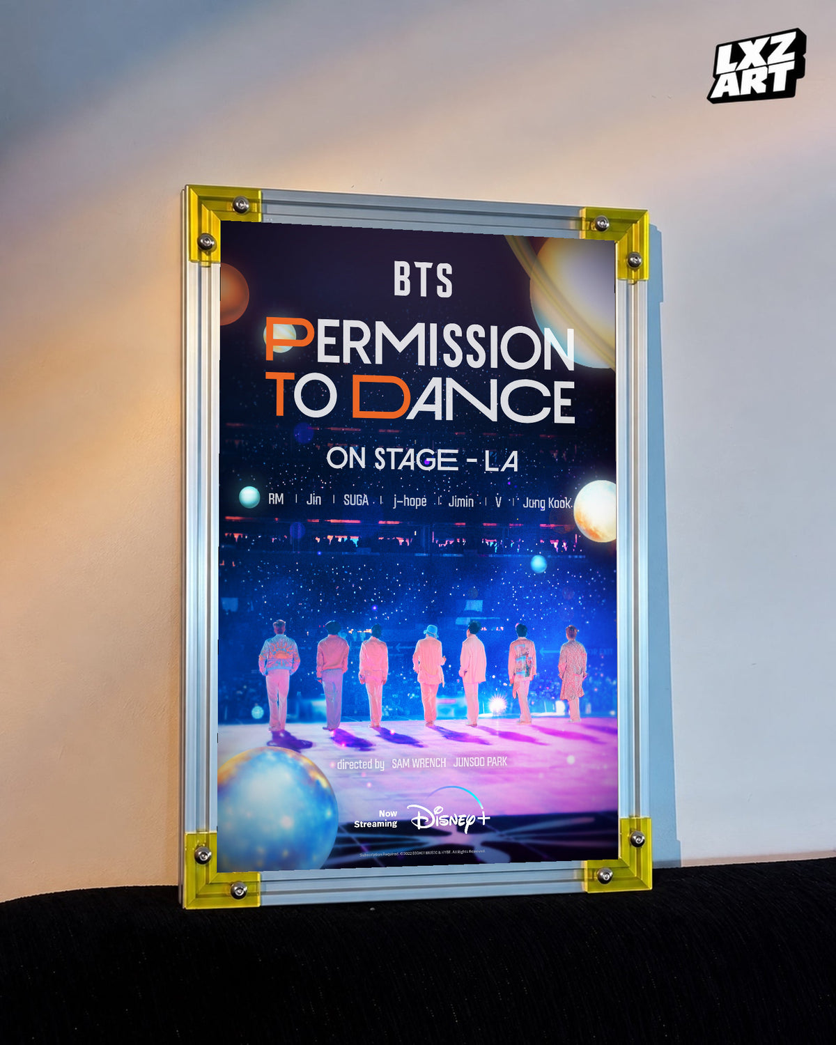 BTS Permission to Dance on Stage LA concert film poster displayed against a warm wall in a yellow-corner frame; unframed print, frame not included