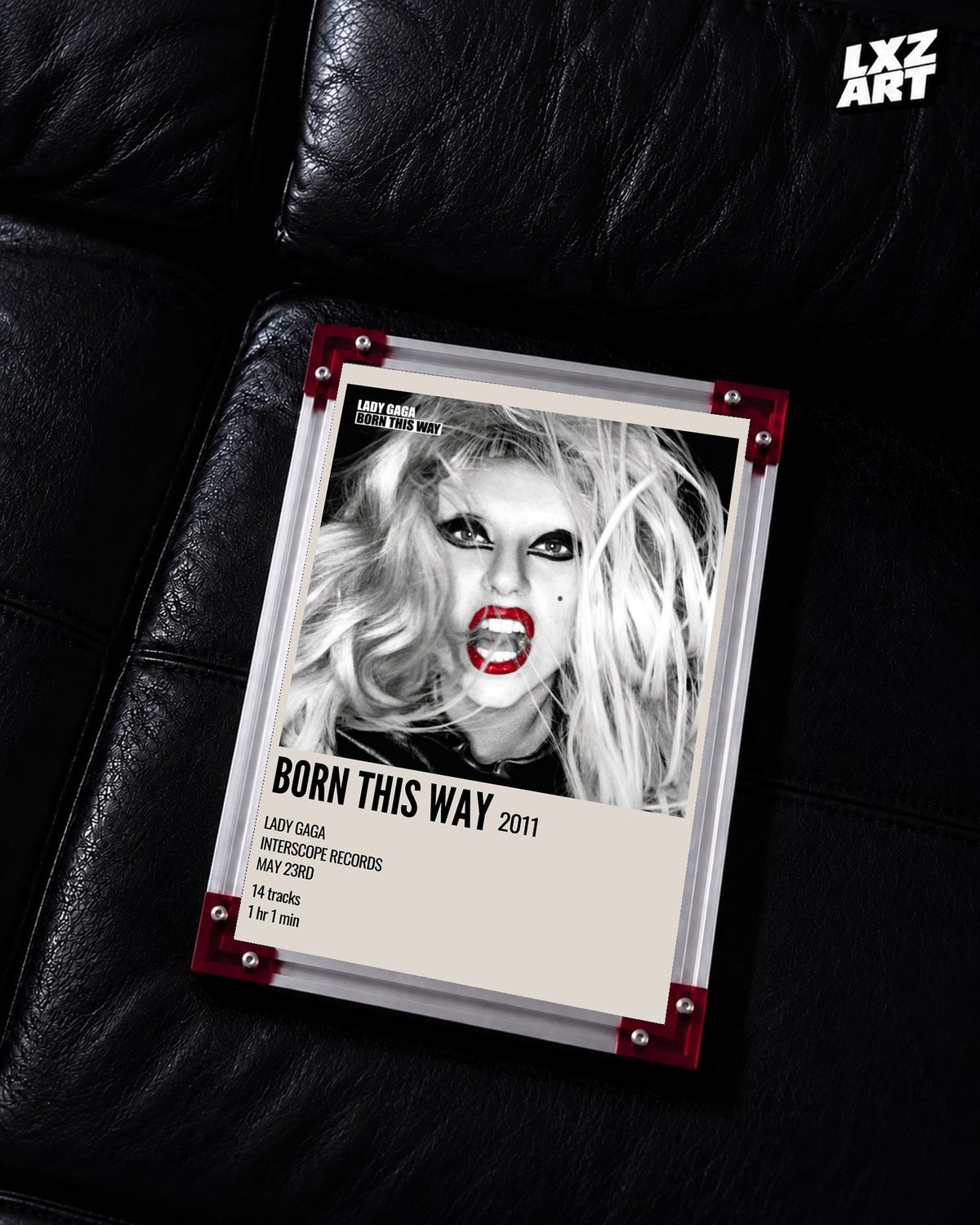 Lady Gaga Born This Way album cover poster displayed on a black leather sofa in a red corner frame; unframed print, frame not included