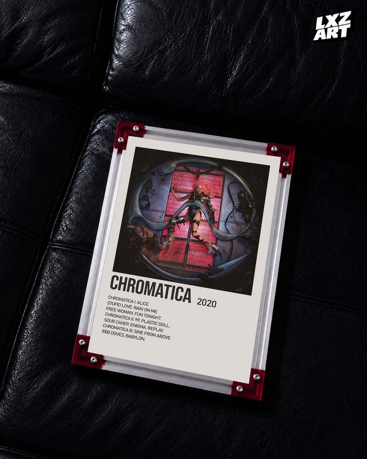 Lady Gaga Chromatica tracklist poster displayed on a black leather sofa in a red corner frame; unframed print, frame not included