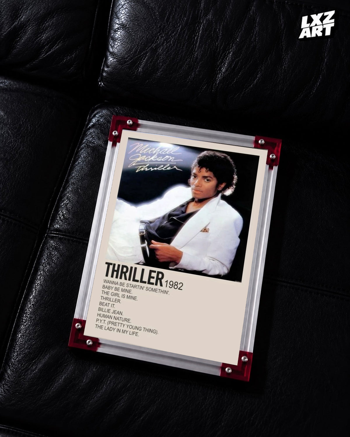 Michael Jackson Thriller tracklist poster displayed on a black leather sofa in a red corner frame; unframed print, frame not included