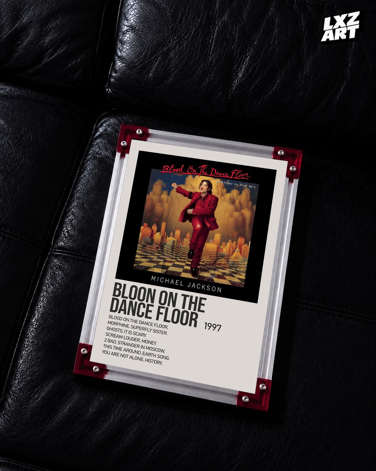 Michael Jackson Blood on the Dance Floor tracklist poster displayed on a black leather sofa in a red corner frame; unframed print, frame not included