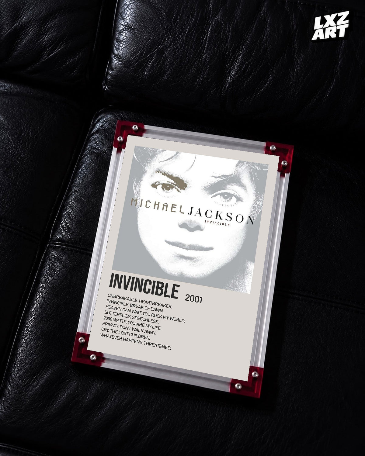Michael Jackson Invincible tracklist poster displayed on a black leather sofa in a red corner frame; unframed print, frame not included