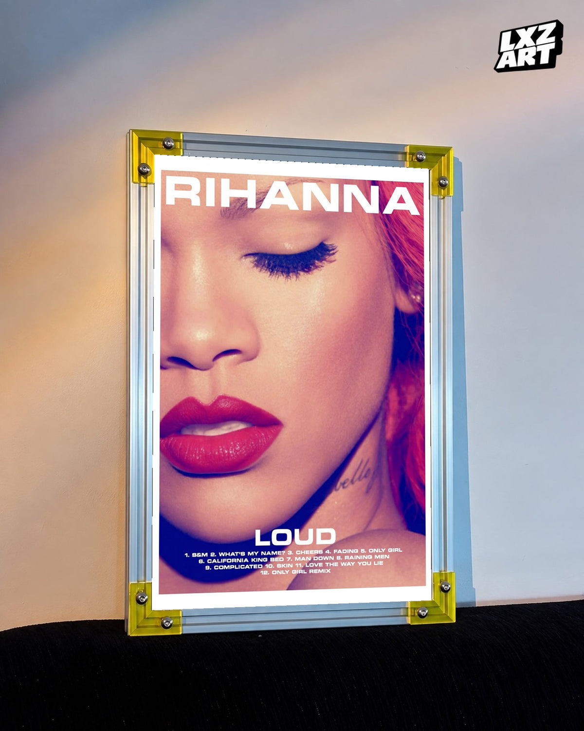 Rihanna Loud album tracklist poster displayed against a warm wall in a yellow corner frame; unframed print, frame not included