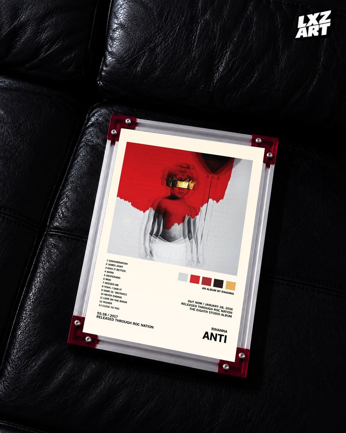 Rihanna Anti album tracklist poster displayed on a black leather sofa in a red corner frame; unframed print, frame not included