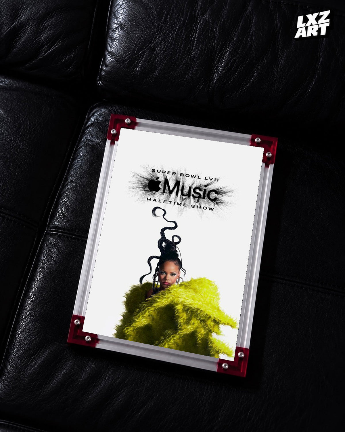 Rihanna Apple Music Super Bowl LVII Halftime Show performance poster displayed on a black leather sofa in a red corner frame; unframed print, frame not included