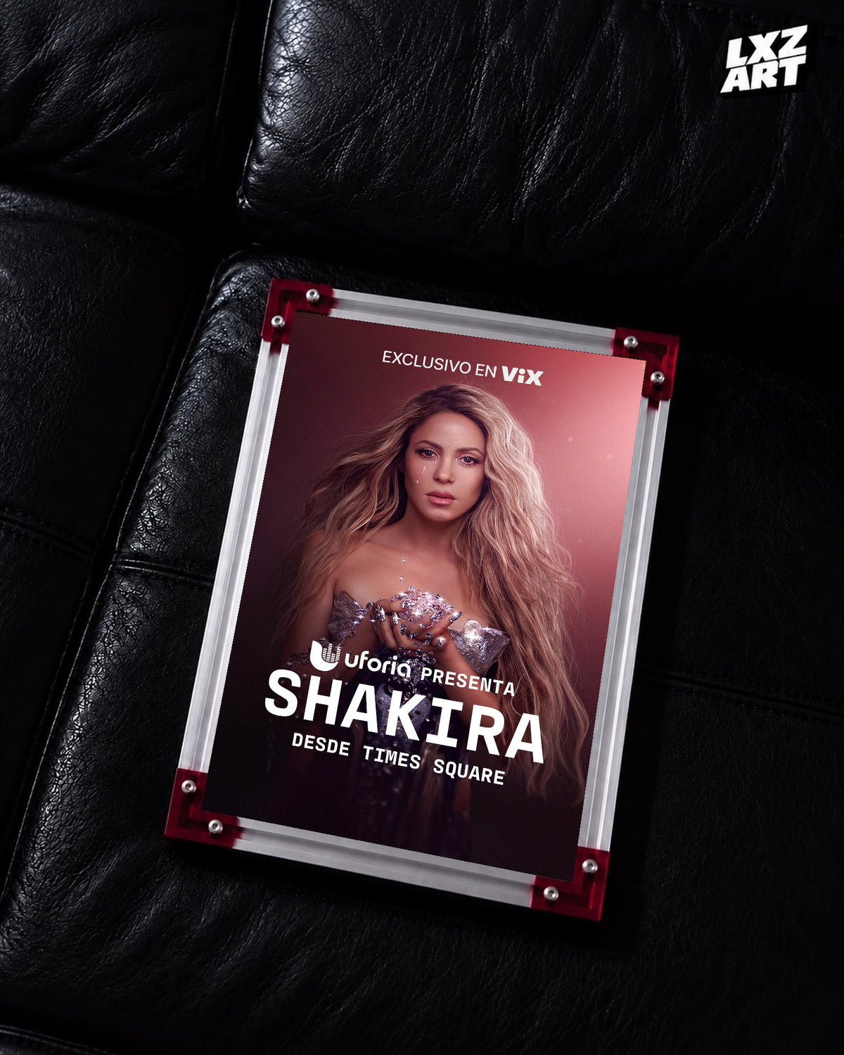 Shakira Desde Times Square live music special poster displayed on a black leather sofa in a red corner frame; unframed print, frame not included