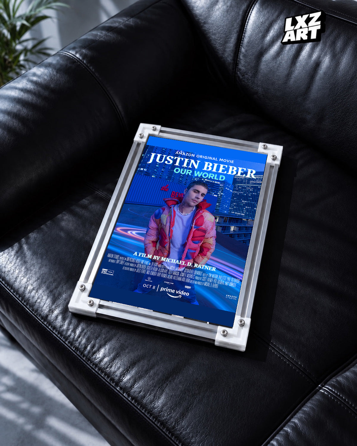 Justin Bieber Our World Blue City Concert Documentary Poster displayed in a white-corner frame on a black leather sofa. Frame for display only.