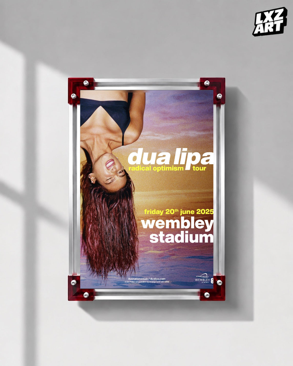 Dua Lipa Radical Optimism Wembley Stadium Tour Poster displayed on a gray wall in a red corner frame; unframed print, frame not included