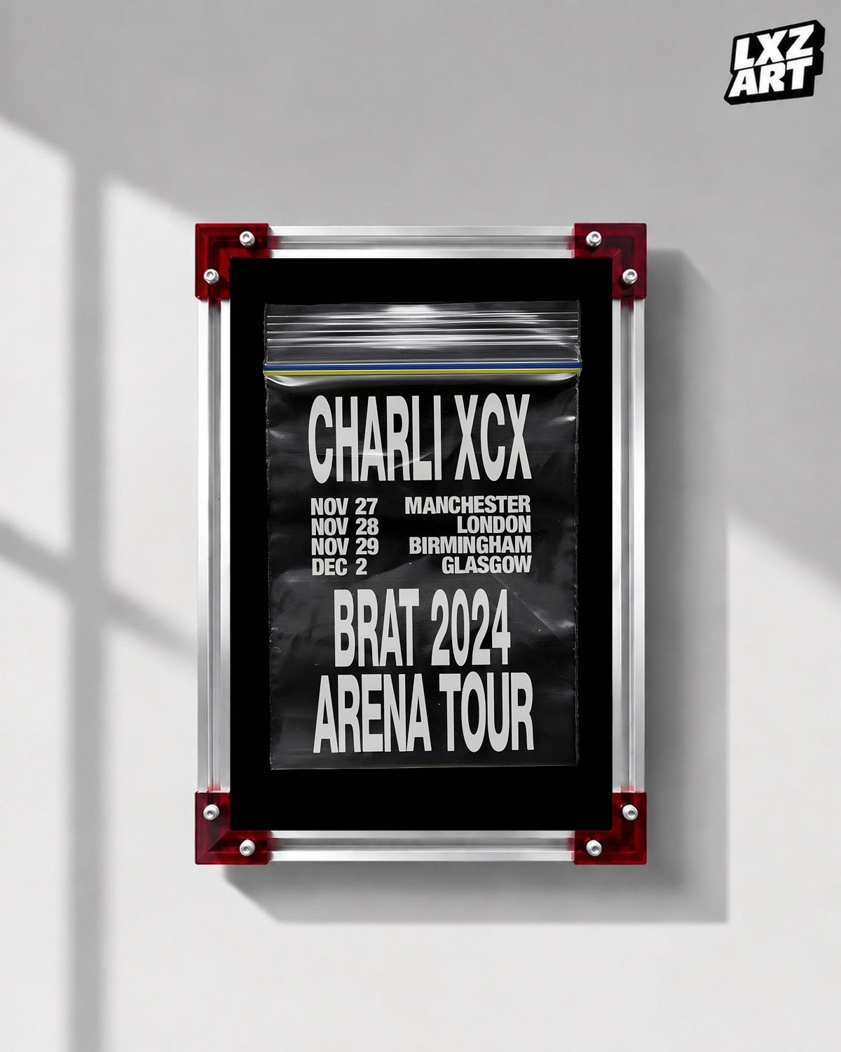 Charli xcx Brat 2024 UK Arena Tour Zip Bag Poster displayed on a gray wall in a red corner frame; unframed print, frame not included