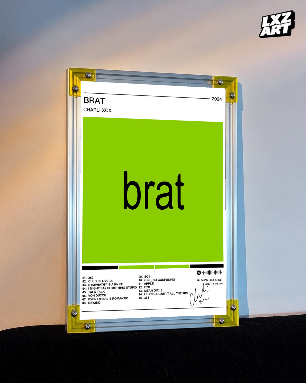 Charli xcx Brat White Tracklist Poster displayed on a warm wall in a yellow corner frame; unframed print, frame not included